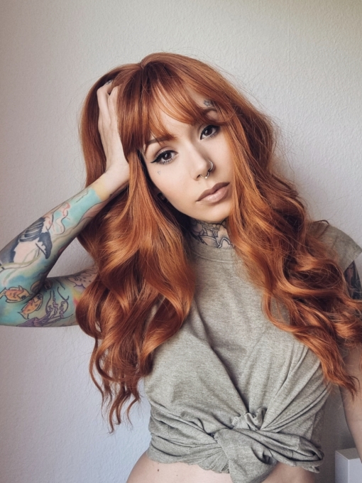 Long layers with loose barrel curls give this style some body. Colette is a natural muted ginger colour from roots to tips with a sleek fringe.