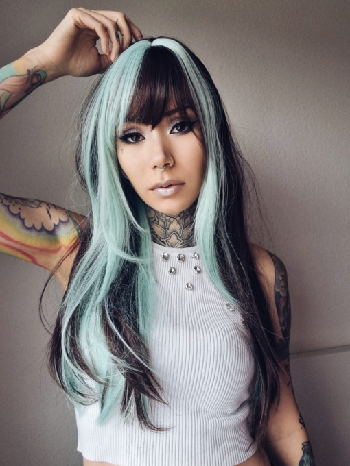 Draven is styled into a sleek blowout, with blunt bangs. Layers that frame the face with a mix of mint green and dark brown. With a block of colour from the nape of the neck, to give a peek-a-boo effect.